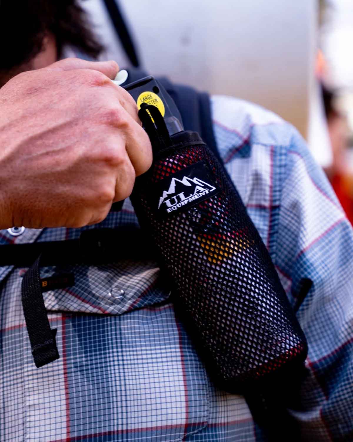 ULA Equipment Deploy|使用画像|左のショルダーハーネスに取り付けて右手でベアスプレーを取り出す様子