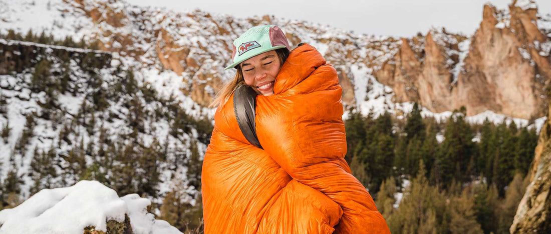 Enlightened Equipment Revelation Quilt Burnt Orange 女性がブランケットとして使用しているイメージ