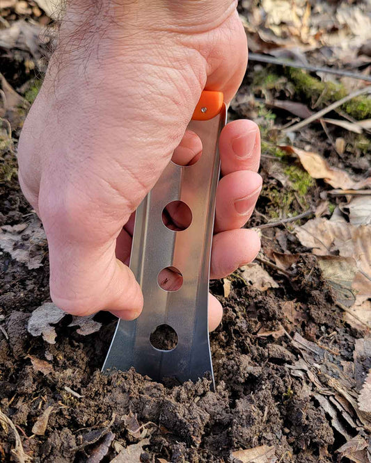 BoglerCo Ultralight Backpacking Trowel｜公式使用イメージ（オレンジ）土を掘る様子