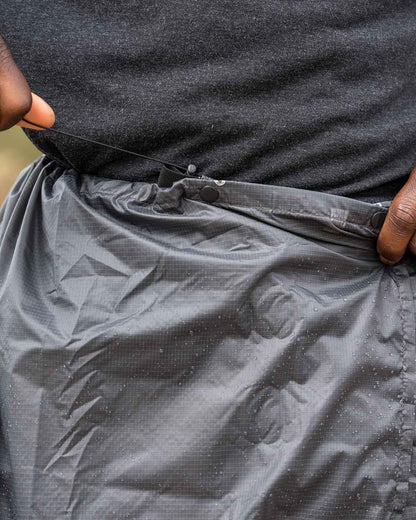 Enlightened Equipment Rain Wrap｜公式画像 ウエストをショックコードで調整している様子